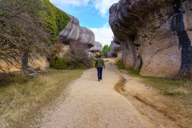 Büyülü Şehir Cuenca 'da devasa aşınmış kayaların arasında yürüyen bir adam. İspanya.