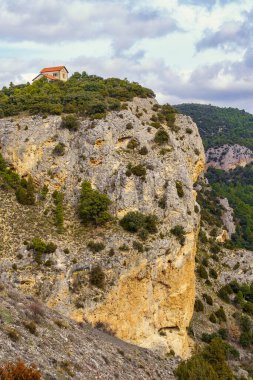 Dağın tepesinde küçük bir evi olan dev bir kayalık..