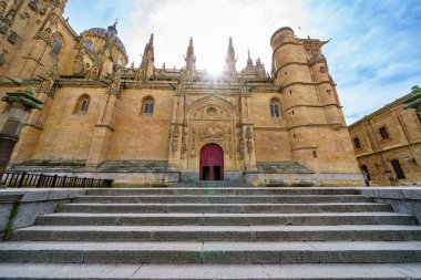 Salamanca 'nın yeni katedralinin ön cephesinde İspanya' daki anıtın arkasında güneş parlıyor..