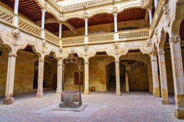 Ortaçağ avlusunda taş kemerler ve çevrenin tam ortasında Salamanca.