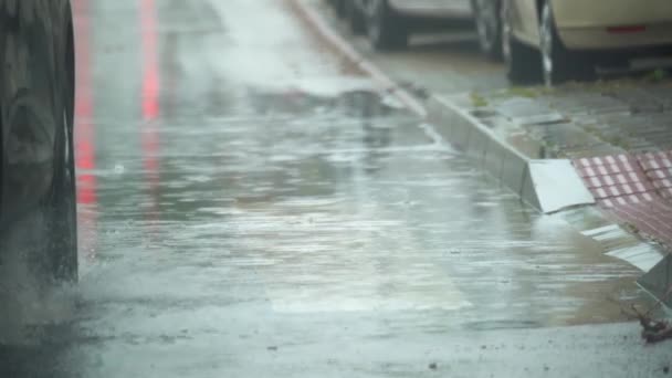 Starker Sturm in der Stadt und Autos, die durch die vom Wasser gebildeten Pfützen fahren. — Stockvideo