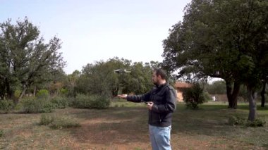 Adamın biri uzaktan kumandayla eline İHA indiriyor..