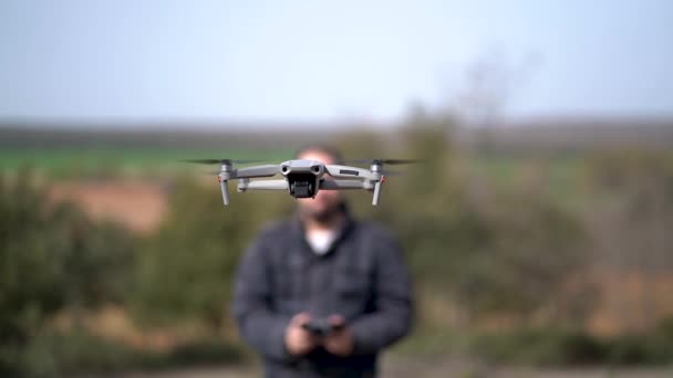 Drohne fliegt vor einem Mann, der sein Gesicht verhüllt. — Stockvideo