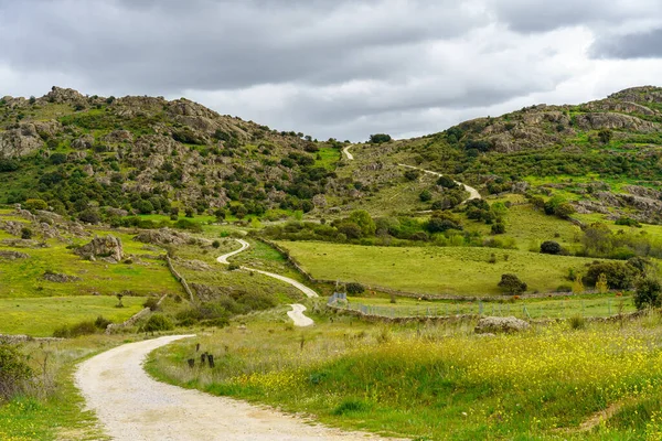 Bulutlu bir günde dağın içinden esen toprak yol, Guadarrama Madrid.