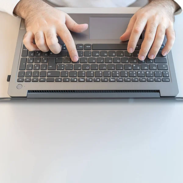 Hands of man typing a laptop, photo with copy space.