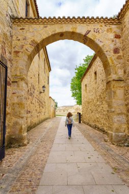 Eski ortaçağ şehrinde taş kemerlerle gezen kadın, Zamora İspanya