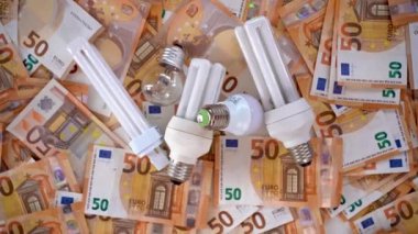 Avro banknotları ve elektrik maliyetini temsil eden farklı ampullerden oluşan arkaplan