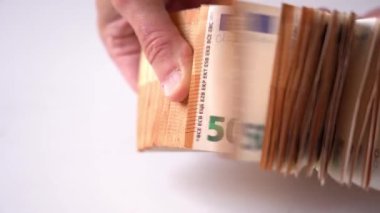 Elli avroluk banknotları olan bir adamın elleri.