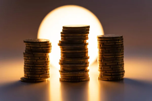 Coins Stacked Front Lit Light Bulb Representing High Cost Electricity — ストック写真