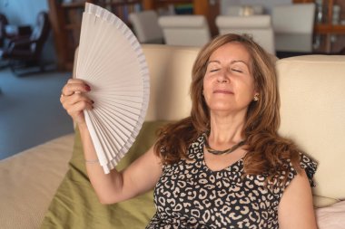 Senior woman with a lot of heat produced by the high temperatures of summer
