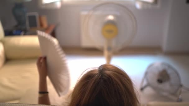 Woman Sitting Sofa Several Fans Giving Her Air Fan Her — Stock video