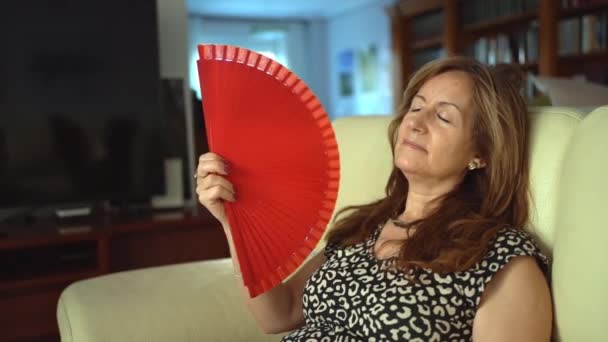 Mature Woman Sitting Sofa Giving Herself Air Fan Slowly Slowmotion — Stockvideo