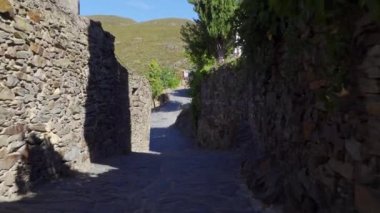 Beautiful alley of stone houses with morning light entering between the buildings. Patones de Arriba Madrid