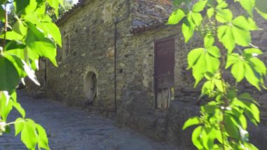 Beautiful alley of stone houses with morning light entering between the buildings. Patones de Arriba Madrid