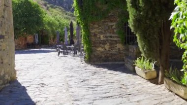 Small alley with stone facades covered by green ivy in spring. Patones de Arriba Madrid