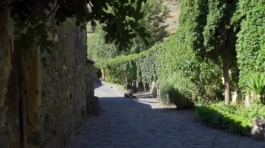Beautiful view of stone houses in the mountains with flowers and cypress trees in the garden. Patones de Arriba Madrid