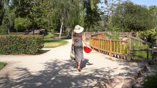Woman Walking Public Park Dress Straw Hat Sunny Summer Day — Stockvideo