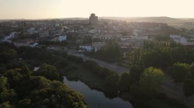 Medieval city on a hill and with the river at its feet in a golden sunset and clear sky with fog, Alba de Tormes, Salamanca