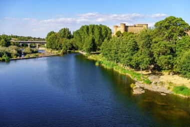 Medieval castle on a hill and next to the Tormes River as it passes through the village of Barco de Avila, Spain