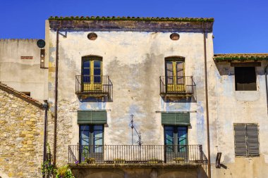 Picturesque facade of old houses with grilled balconies in the medieval town of Besalu, Girona