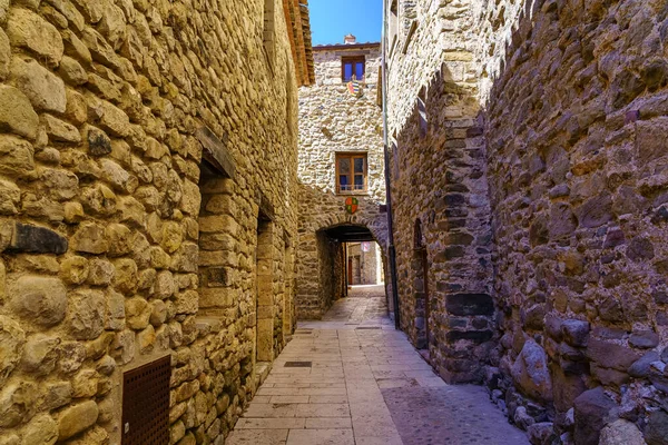 Picturesque narrow alley with houses built entirely of stone in the medieval town of Besalu, Girona