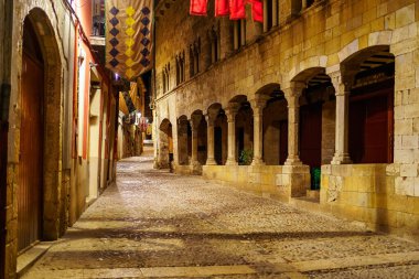 Ancient buildings with arches and stone columns in the picturesque town of Besalu, Girona, Spain