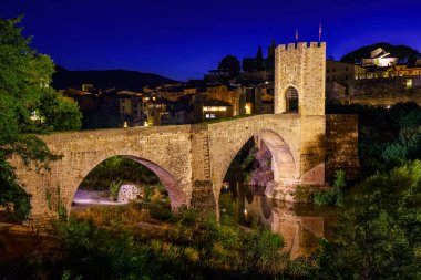 Medieval bridge that crosses the river in the ancient city of Besalu at night, Gerona, Spain