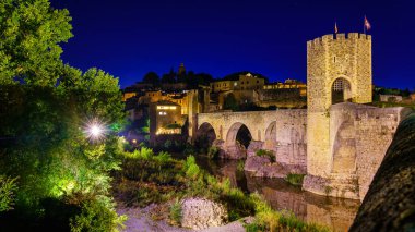Medieval bridge that crosses the river in the ancient city of Besalu at night, Gerona, Spain