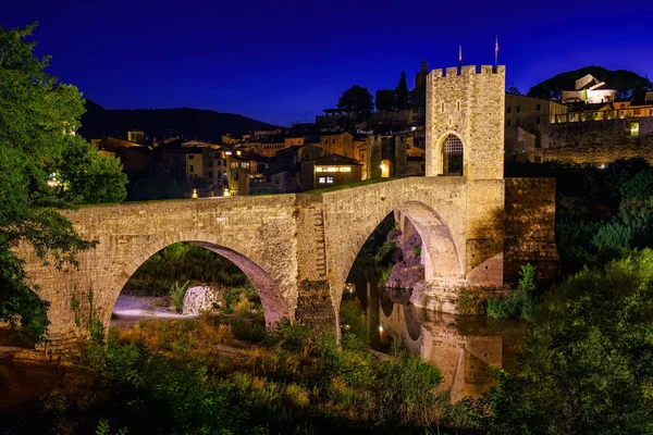 Medieval bridge that crosses the river in the ancient city of Besalu at night, Gerona, Spain