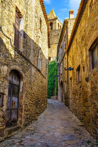 Narrow alleys with medieval stone houses in the old village of Madremanya, Girona