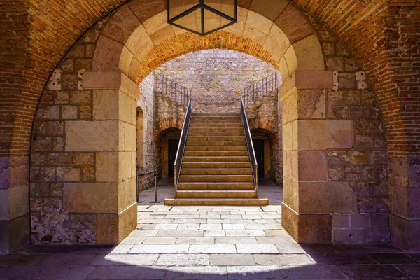 Ancient stone arches and staircase up to the esplanade of Montjuic Castle in Barcelona, Spain