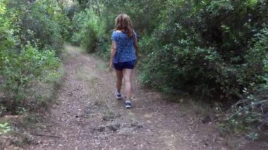 Vahşi doğada, ormanda sessizce gezinen bir kadın.