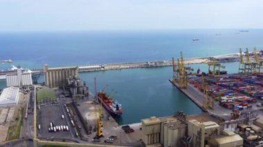 Barcelona limanındaki endüstriyel konteynır limanının hava görüntüsü. Büyük gemiler vinçleri yükleyip boşaltıyor.