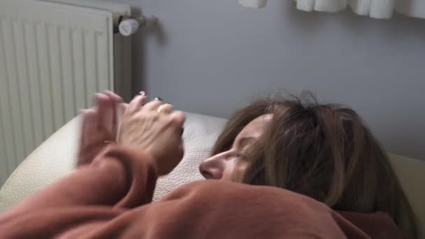 Γυναίκα Ξαπλωμένη Έναν Καναπέ Και Τυλιγμένη Μια Κουβέρτα Πηγαίνει Πολύ — Αρχείο Βίντεο