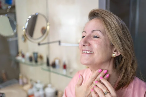 Voksen Hvid Kvinde Der Anvender Kosmetik Creme Ansigt Hals Til - Stock-foto