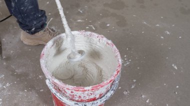 Macun karışımını duvar macunu için bir kovada karıştırıcı ile karıştır.