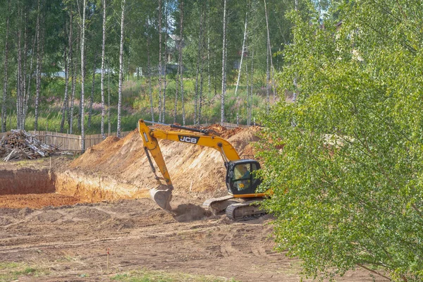 Rusya Kostroma 07 23 2021 Kazıcı bir ev inşaatı için bir çukur kazıyor, temelinin inşası için kum kazıyor..