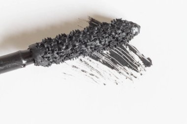 Maskara fırçası beyaz arka planda siyah rimel ile yakın plan.