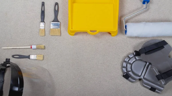 Набор инструментов для покраски стен краской. Кисти, лоток, ролики на бетонном полу — стоковое фото