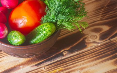 Taze sebze, domates, salatalık, dereotu, turp salatası ve ahşap bir masa için gerekli malzemeler..