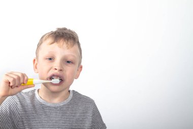 Beyaz çocuk dişlerini kömürlü siyah diş macunuyla fırçalıyor..