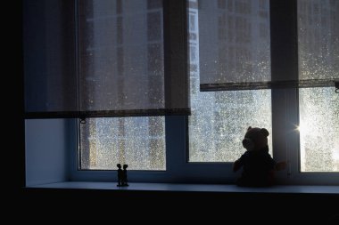 Yağmurlu bir sabah ya da akşam camında su damlaları olan karanlık bir pencerenin silüeti..