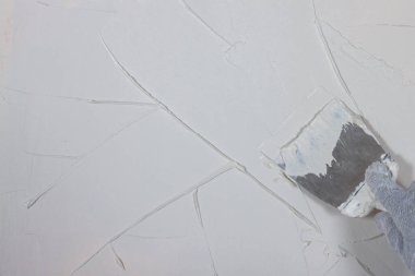 Beton bir duvara spatulayla beyaz macun sür..