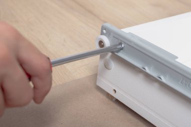 Mobilyaları monte ederken vidayı tornavidayla vidalıyor..