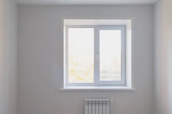 家の中の灰色の壁に光窓と白いラジエーター — ストック写真