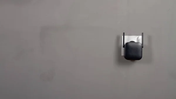 Ein Schwarzer Wlan Signalverstärker Wird Eine Steckdose Auf Grauem Wandhintergrund — Stockfoto