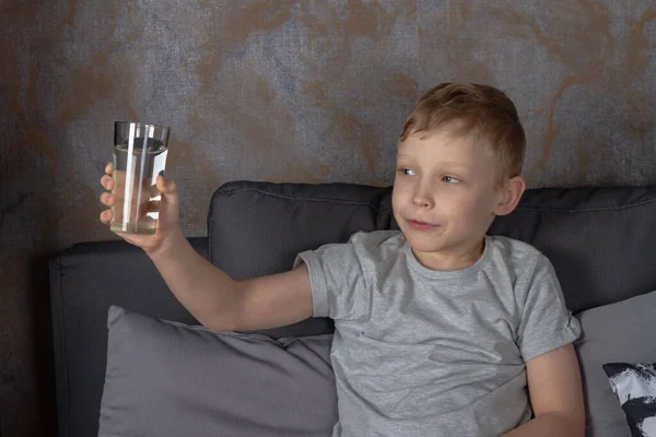 Garçon Caucasien Boit Eau Verre Assis Sur Canapé Gris — Photo