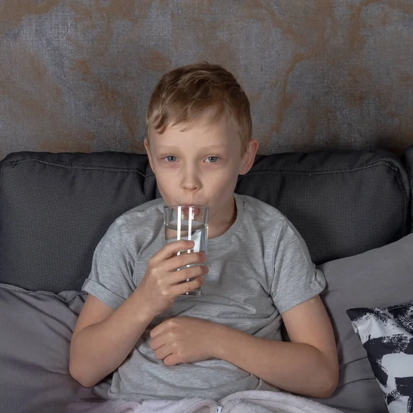 Een Blanke Jongen Drinkt Water Uit Een Glas Terwijl Hij — Stockfoto