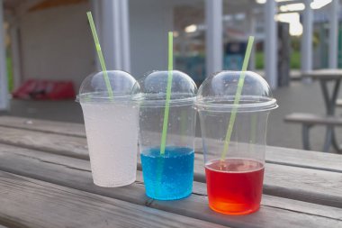 Plastik bardaklarda karbonatlı su ve bir yaz günü bir sokak kafesinde kokteyl tüpleri..