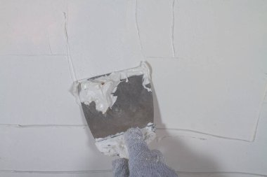Beton bir duvara spatulayla beyaz macun sür..
